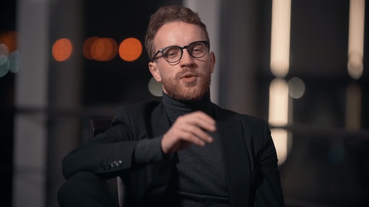 retrato de un joven elegante con traje de negocios hablando mirando a la cámara