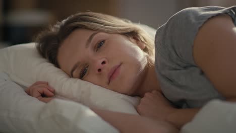 Blonde-caucasian-woman-sleeping-in-white-duvet-at-the-sunny-morning.