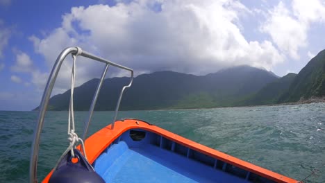 cruising on a bumpy boat in a sea along the coast of breathtaking mountains