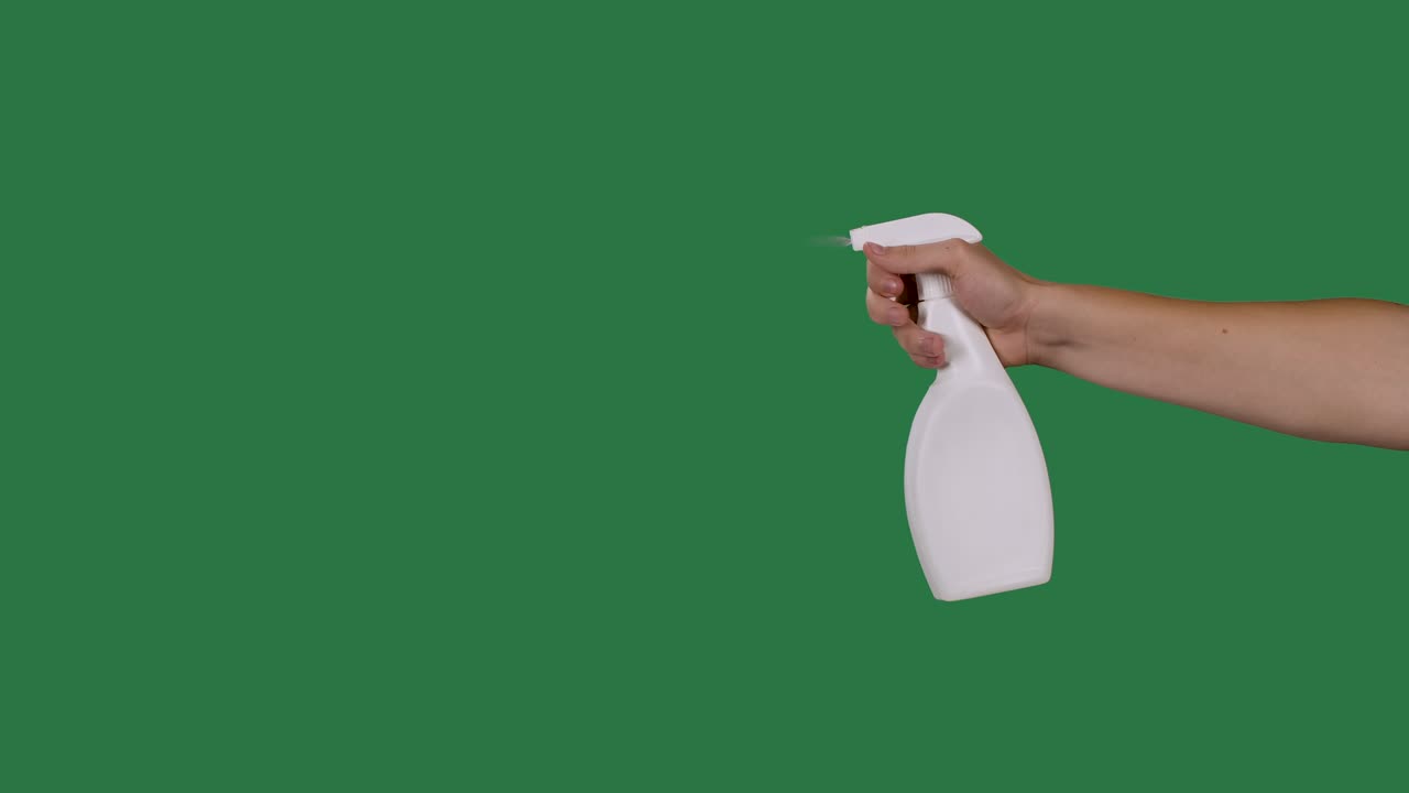 la mano masculina sostiene una botella de spray y rocia un agente de alcohol desinfectante para desinfectar el virus de la corona covid 2019. pantalla verde, llave de croma. cámara lenta. primer plano