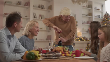 grandpa uncorks a bottle of wine for a toast