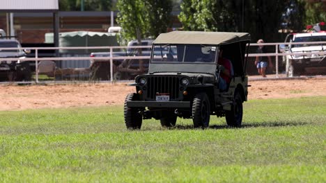 old-fashioned jeep driving through an open field