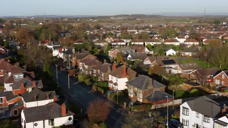aerial view expensive british middle class houses in rural suburban neighbourhood during golden hour
