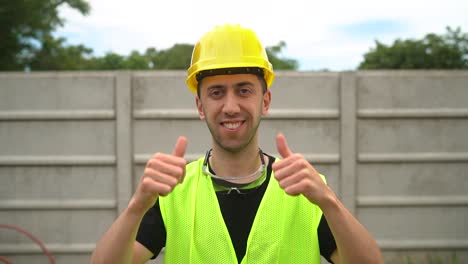 Un-Trabajador-De-La-Construcción-Que-Llevaba-Un-Casco-Amarillo-Expresó-Su-Aprobación-Levantando-Dos-Pulgares-(primer-Plano-Medio)