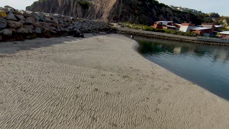 Epischer-Tiefflug-FPV-Blick-Entlang-Des-Sandstrandes,-Der-über-Den-Steg-Bis-Zum-Meer-Ansteigt