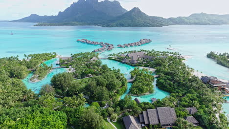 bora bora, french polynesia. aerial view of luxury resort with bungalows over water, lagoon and island
