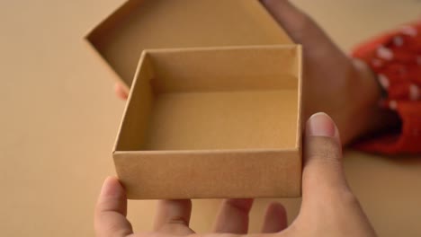 hands holding an empty cardboard gift box