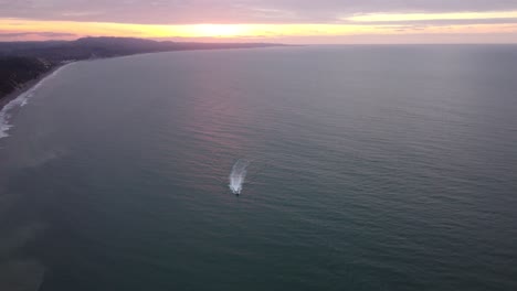 Boat-cruising-at-sunset-in-Same-beach,-Ecuador