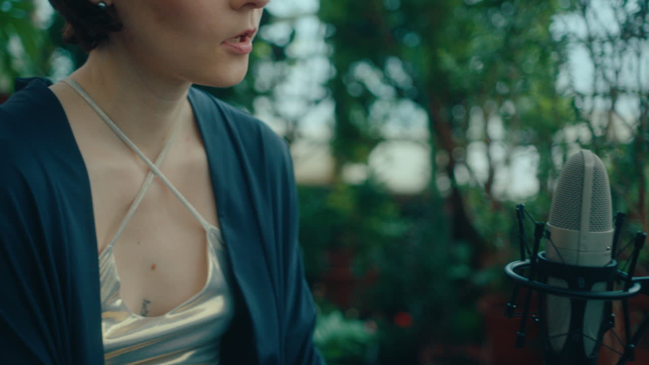 Female Musician Playing Piano and Singing into Mic in Indoor Garden