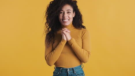 una mujer afroamericana sorprendida sobre un fondo naranja.
