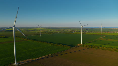 spinning wind towers generating energy in fields. drone view of wind turbines.