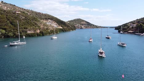 Veleros-Flotantes-En-Mikros-Gialos,-Isla-De-Lefkada,-Grecia---Antena