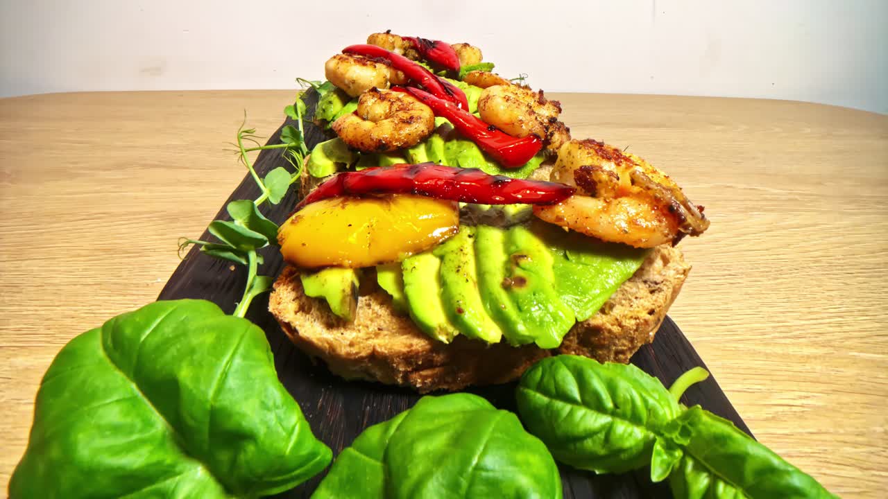 Grilled shrimp, avocado, and peppers on a wooden table, shot close-up