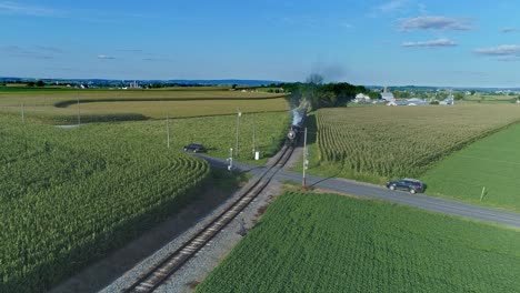 An-Aerial-View-of-an-Antique-Steam-Passenger-Train-Blowing-Smoke-and-Steam-Traveling-Thru-Fertile-Corn-Fields-on-a-Beautiful-Sunny-Summer-Day