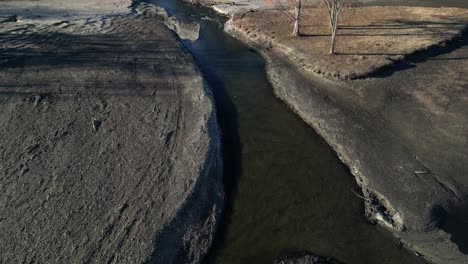 un flujo de río que está mal erosionado con árbol seco en el fondo