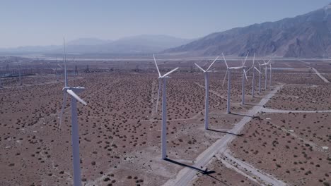 El-Lento-Avance-Del-Dron-Captura-Una-Línea-De-Molinos-De-Viento-En-Funcionamiento-En-El-Desierto