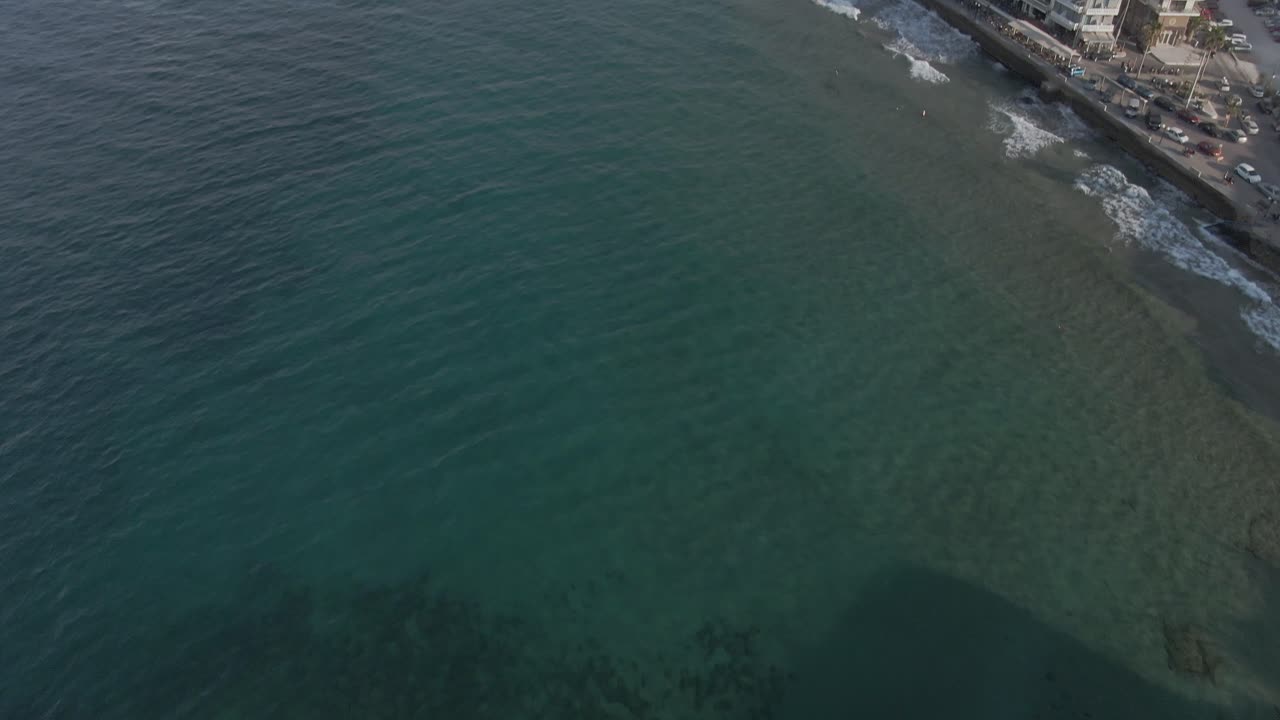 크레타에 있는 이국적인 흰색 도시 차니아 리조트, 물에서 도시까지 드론 뷰를 기울임