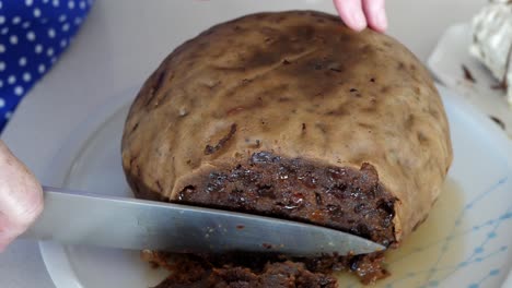 Large-Knife-Cutting-Christmas-Pudding-Sitting-On-Plate