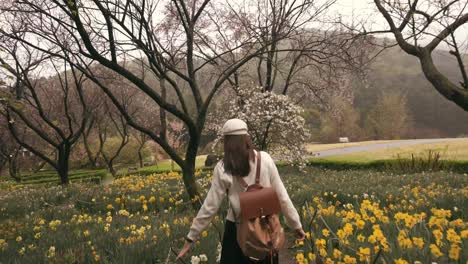 a-girl-walking-leisurely-along-a-path-lined-with-vibrant-flowers-and-through-a-lush-forest,-encapsulating-the-essence-of-a-peaceful-nature-retreat