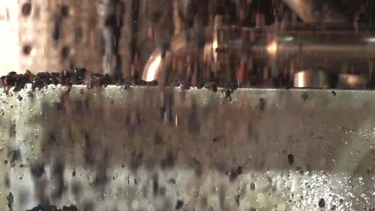 포도 기 기계 에서 포도 제조 장치 로 흘러 내리는 부서진 포도 의 근접 촬영