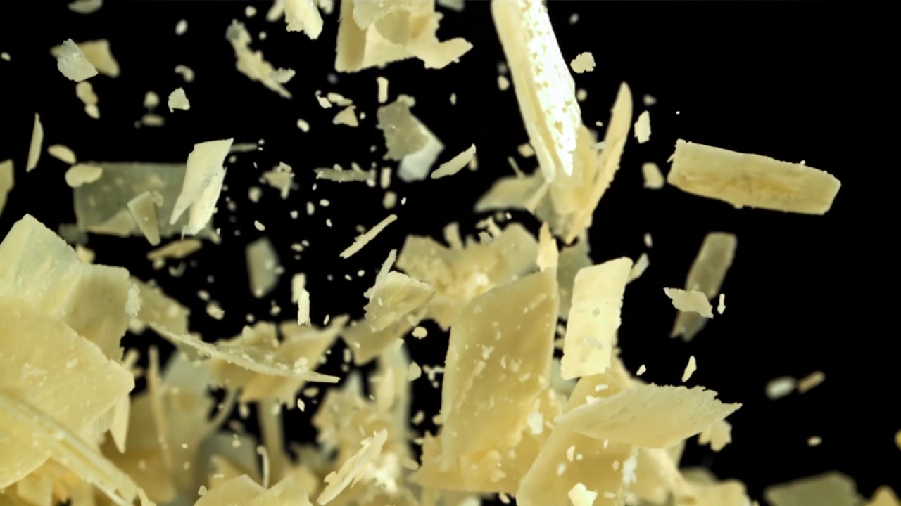 Close-up of Parmesan Cheese Flakes Falling in Slow Motion