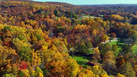 A-high-angle-aerial-view-over-the-quiet-countryside-of-New-Jersey-with-colorful-trees-all-around-on-a-sunny-day-in-autumn