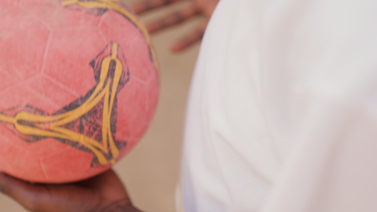 Energia juvenil no esporte de rua. Atleta alegre soltando a bola em meio a uma animada partida comunitária. Momento energético capturando a vibrante atividade de esporte de rua com jogadores felizes e atmosfera contagiante.