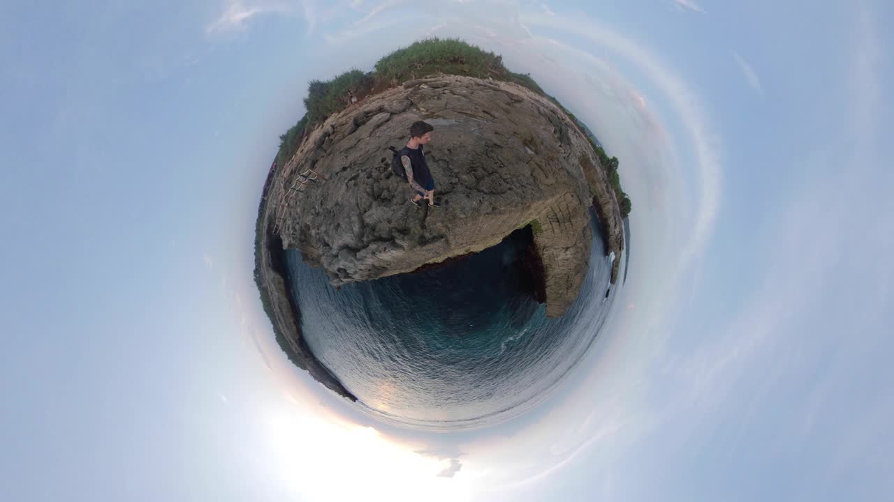 Человек, стоящий на скале с видом на океан.