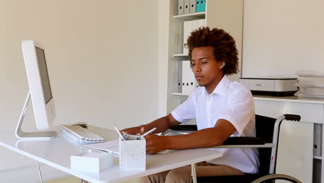 Wheelchair-user-working-at-his-desk