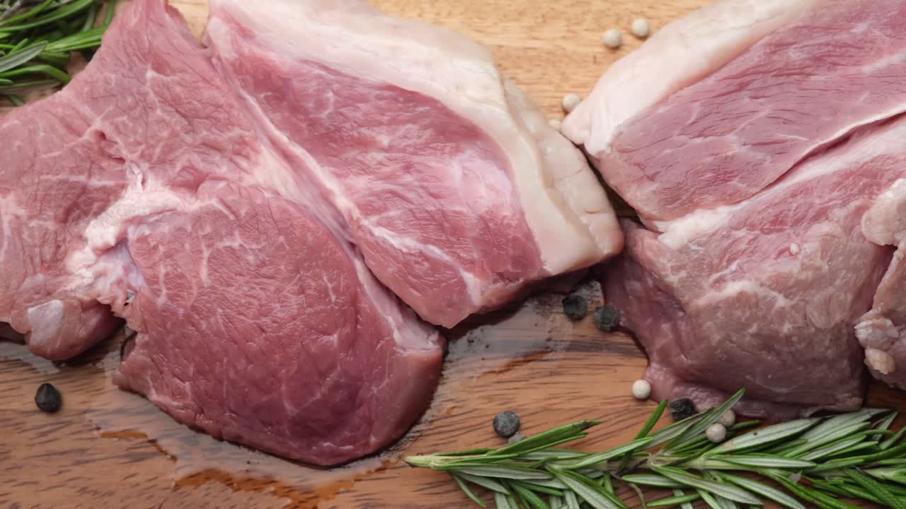 chuletas de cordero crudas con romero y granos de pimienta