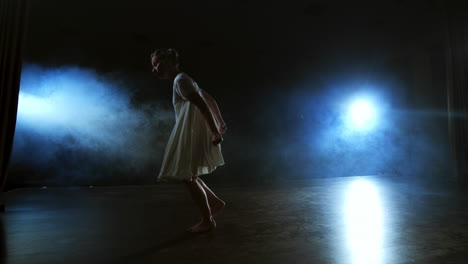 slow-motion: female dancer on stage in smoke. modern ballet barefoot on stage.