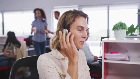 Professionelle-Geschäftsfrau-Lächelt,-Während-Sie-In-Zeitlupe-Am-Telefon-Headset-Im-Modernen-Büro-Spricht