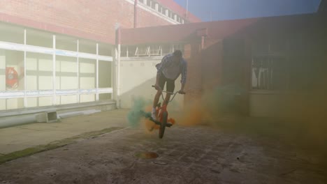 BMX-rider-in-an-empty-warehouse-using-smoke-grenade