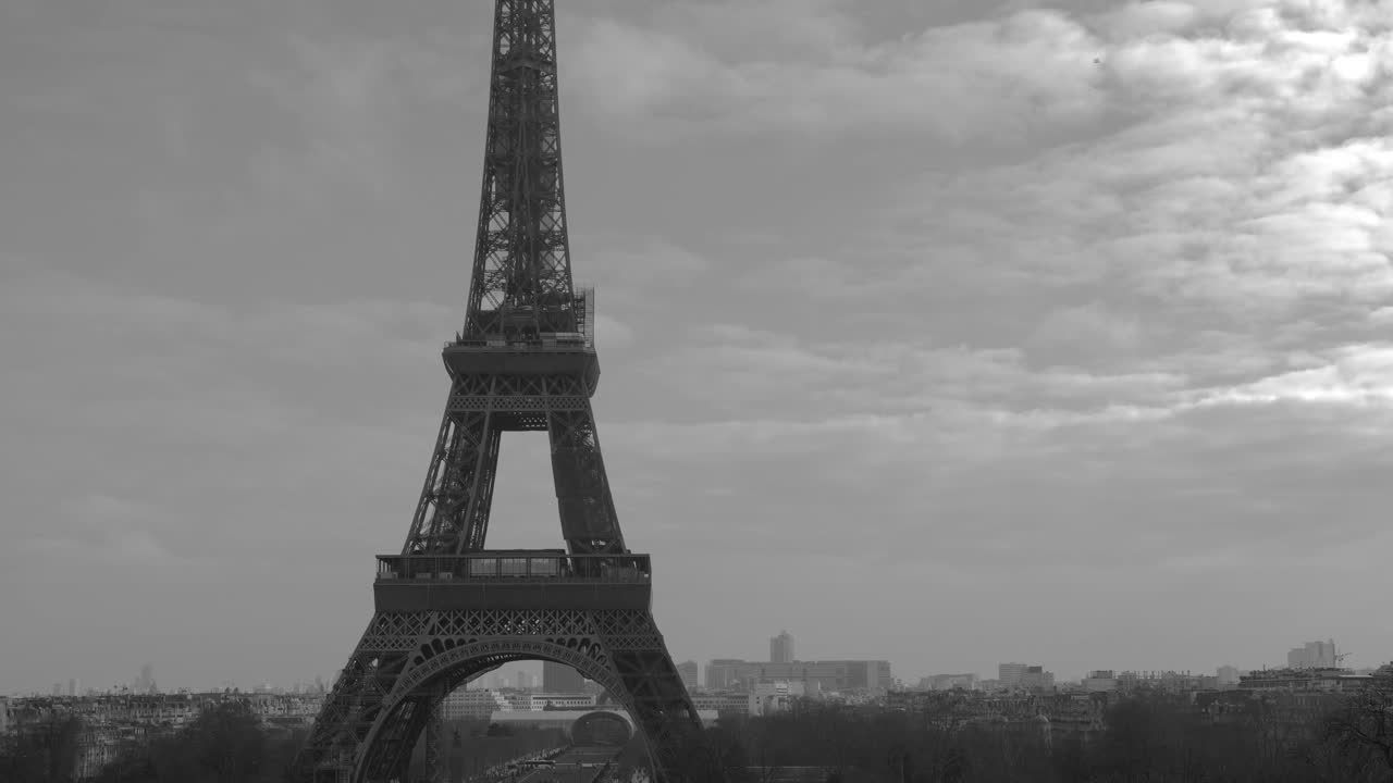 Tilt up black and white shot of Eiffel tower from famous square Trocadero, most visited attractions of Paris, France on a cloudy day