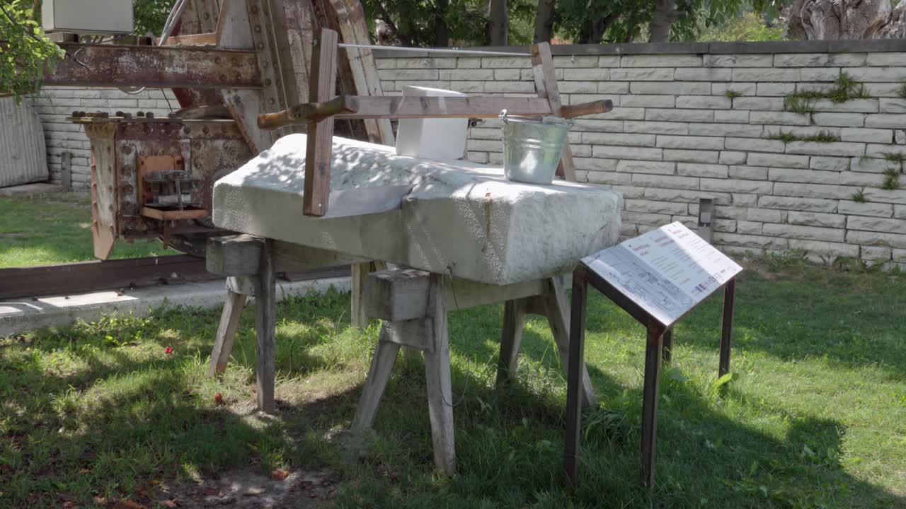 A block of marble with a saw, bucket and other objects on display during the open day at Lasa Marmo at the annual Marble and Apricot Festival in Laas - Lasa, South Tyrol, Italy