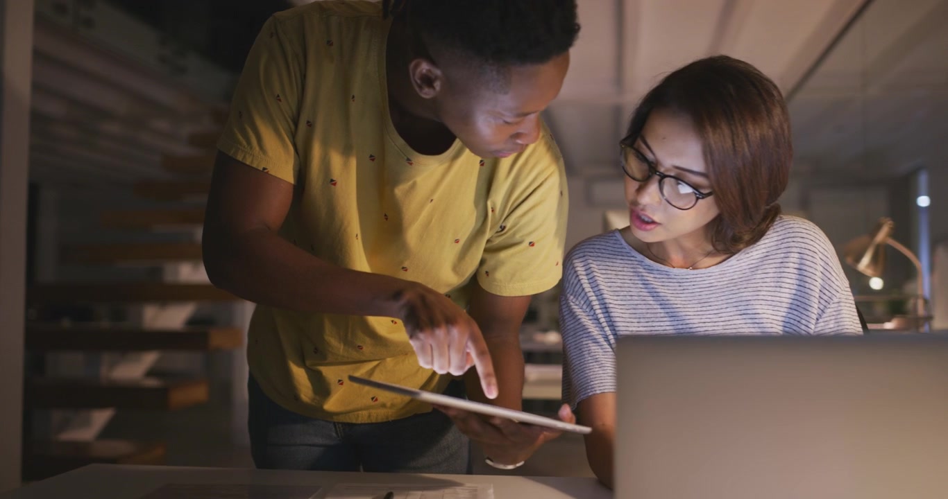 Colleagues Collaborating on a Project in a Modern Office at Night
