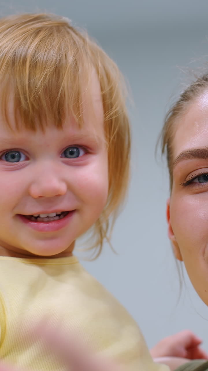 la tía y la sobrina comparten un momento alegre en un gimnasio bien iluminado, sonriendo cálidamente a la cámara, un gran espejo refleja sus espaldas, capturando su felicidad en un moderno espacio de fitness