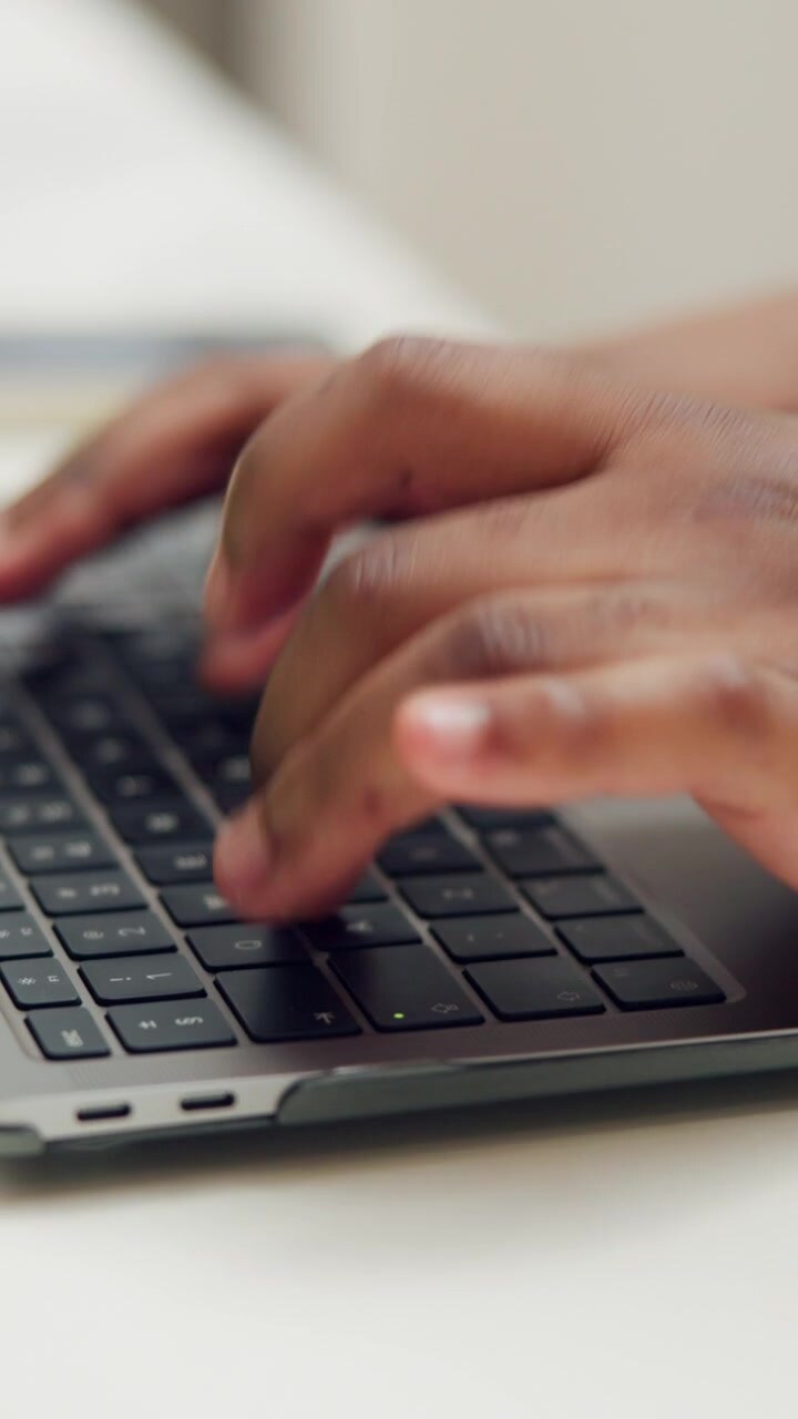 Primo piano di una persona che digita sulla tastiera di un laptop