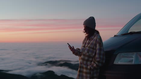 beautiful young woman with a phone at sunset