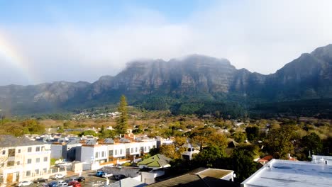 a beautiful rainbow after rain on a misty day with clouds rolling over the mountain