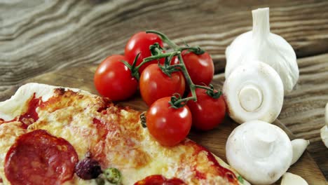 italian pizza on wooden table with vegetables and spices