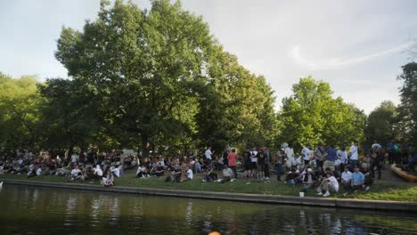 Eine-Große-Gruppe-Von-Menschen-Versammelte-Sich-In-Der-Nähe-Eines-Sees-In-Berlin,-Deutschland