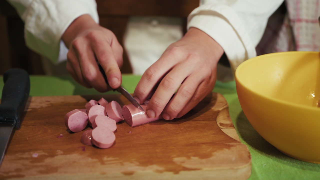 Mãos de um Chef Particular Dividem Linguiça Numa Tábua de Corte de Madeira Sobre a Mesa