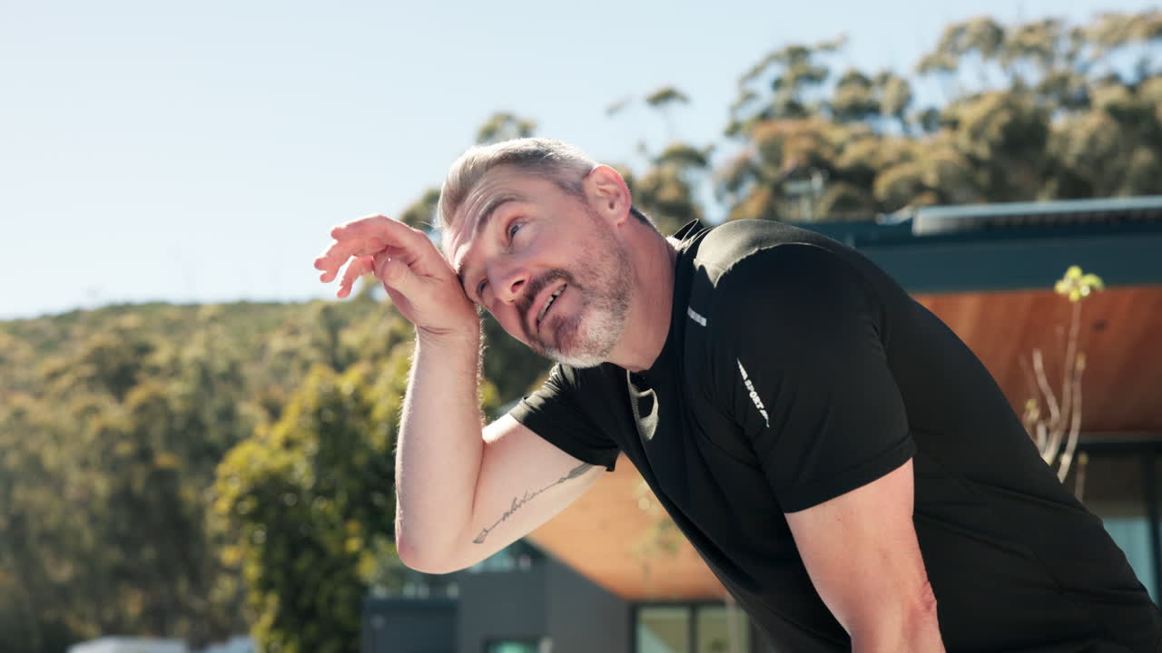 Tired Man Wiping Sweat from Forehead After Outdoor Workout