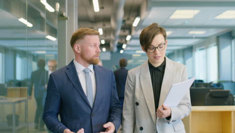 colleagues walking in office and discussing business