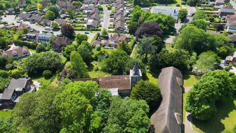 Slow-drone-footage-flying-over-the-village-church-of-Littlebourne,-Kent