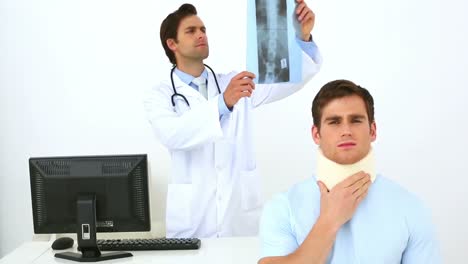 Doctor-examining-xray-of-injured-patient-in-neck-brace