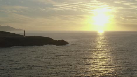 drone disparó panorama de un faro a la hora dorada con el océano y el sol