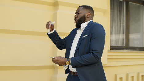 african business man throwing cash in the street