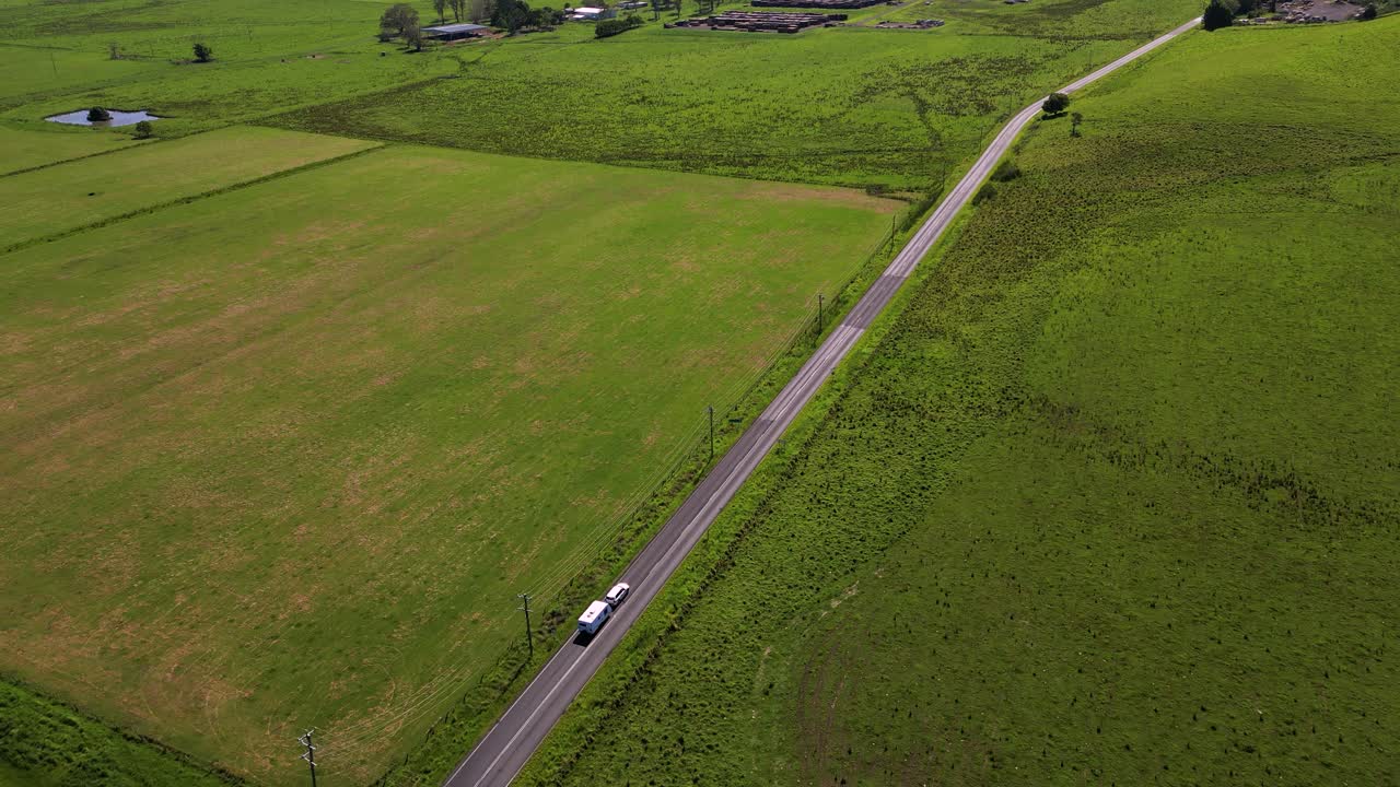 Aerial footage of a 4wd and caravan driving through farmland surrounding Kyogle in Northern New South Wales, Australia